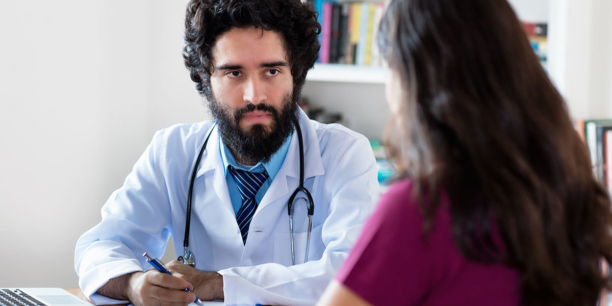 Pakistani male doctor talking to female patient a doctor talks to a woman asking what is physical dependence