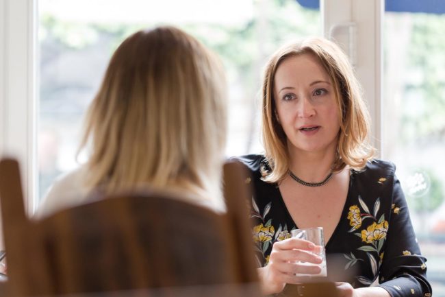 a woman sits and talks with another woman about if its possible to convince someone to go to rehab