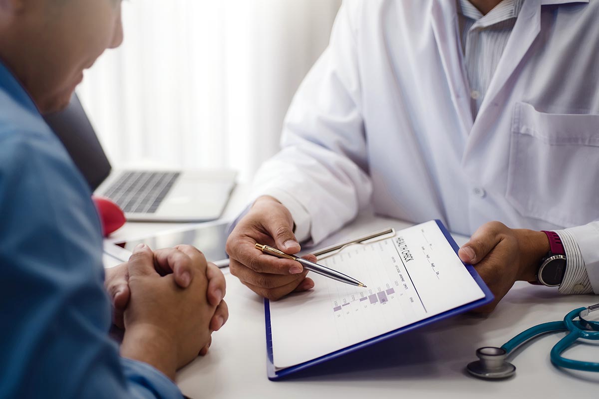 Understanding the Difference Between Dependence Vs Addiction (1) a doctor shows a patient information on a tablet about dependence vs. addiction