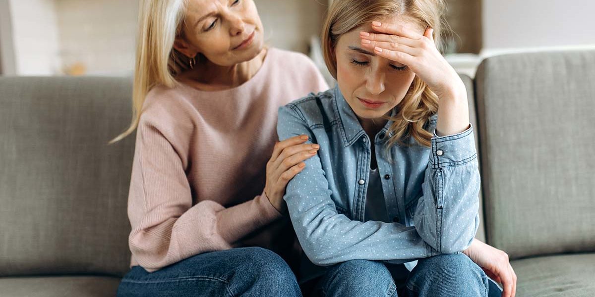 a woman helps a loved one into alcohol treatment