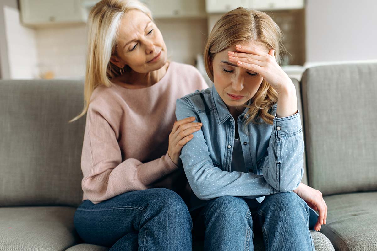 a woman helps a loved one into alcohol treatment