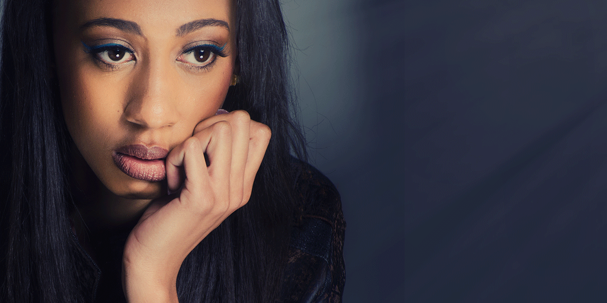 a woman has hand to her fade looking afar thinking about long-term alcohol abuse