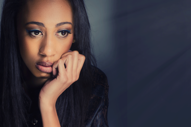 Recognizing-Long-Term-Alcohol-Abuse a woman has hand to her fade looking afar thinking about long-term alcohol abuse