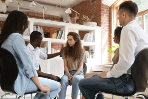 a group of people talk in group therapy while participating in cocaine addiction treatment