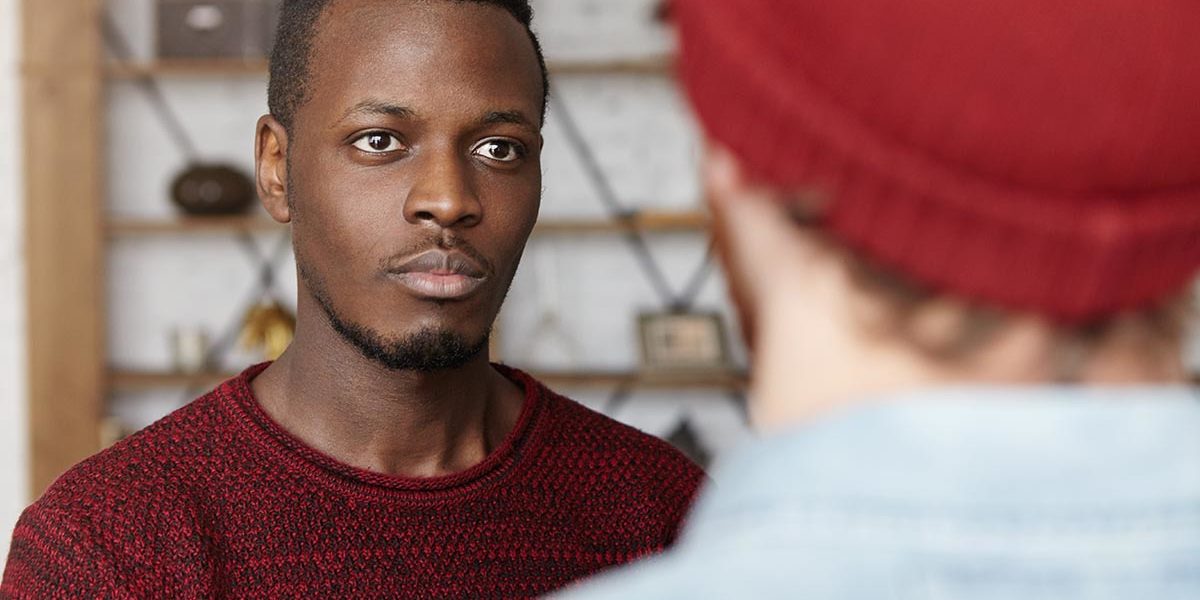 a man looks and listens to a man standing in front of him who is talking about how to help someone with meth addiction