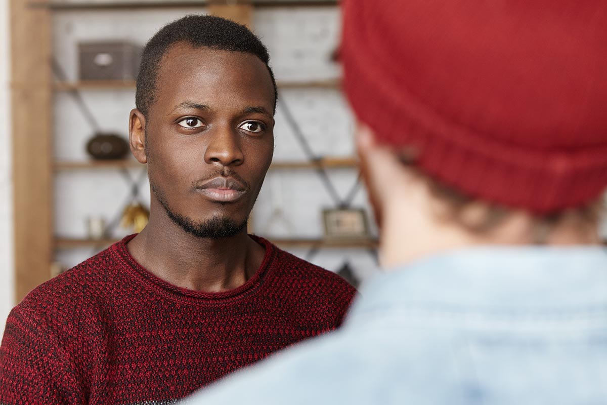 a man looks and listens to a man standing in front of him who is talking about how to help someone with meth addiction