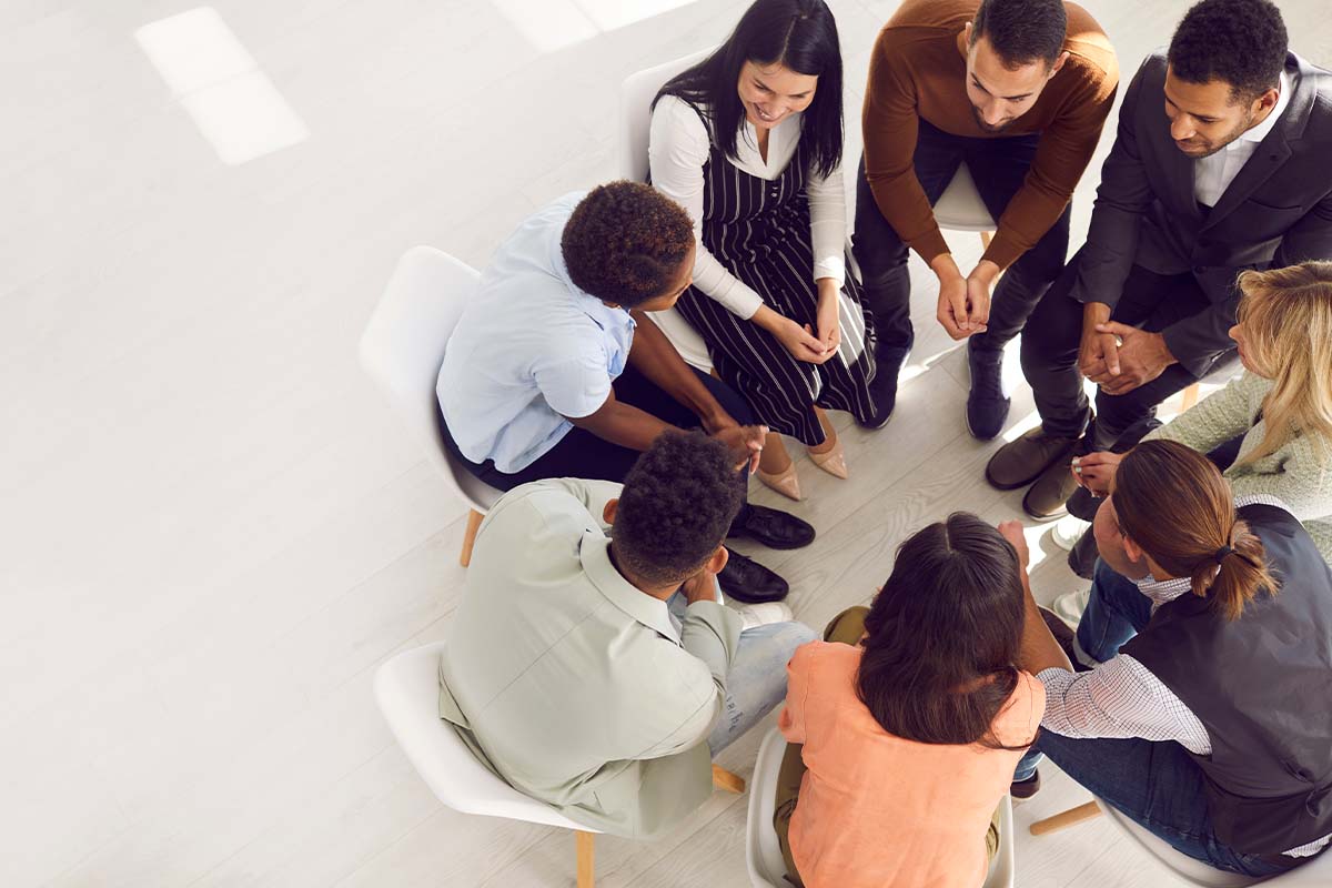 What Are the Benefits of IOP a group of people sit in a circle discussing the benefits of IOP for their recovery