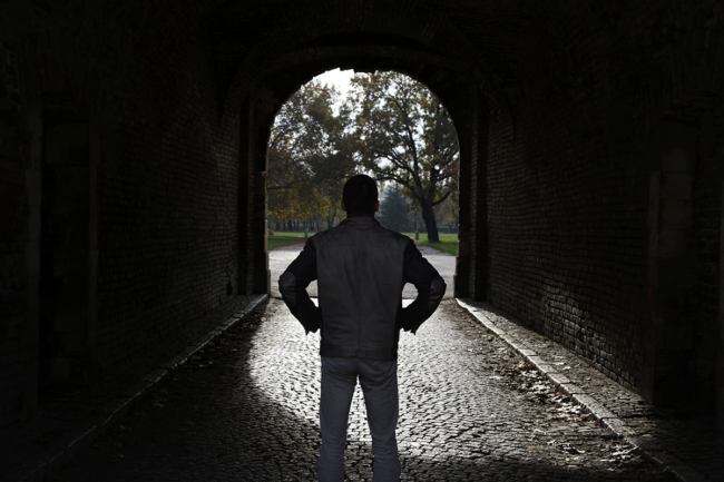 How-to-Start-Your-Recovery-to-Sobriety man stands outside in a dark tunnel and thinks about how to start his recovery to sobriety