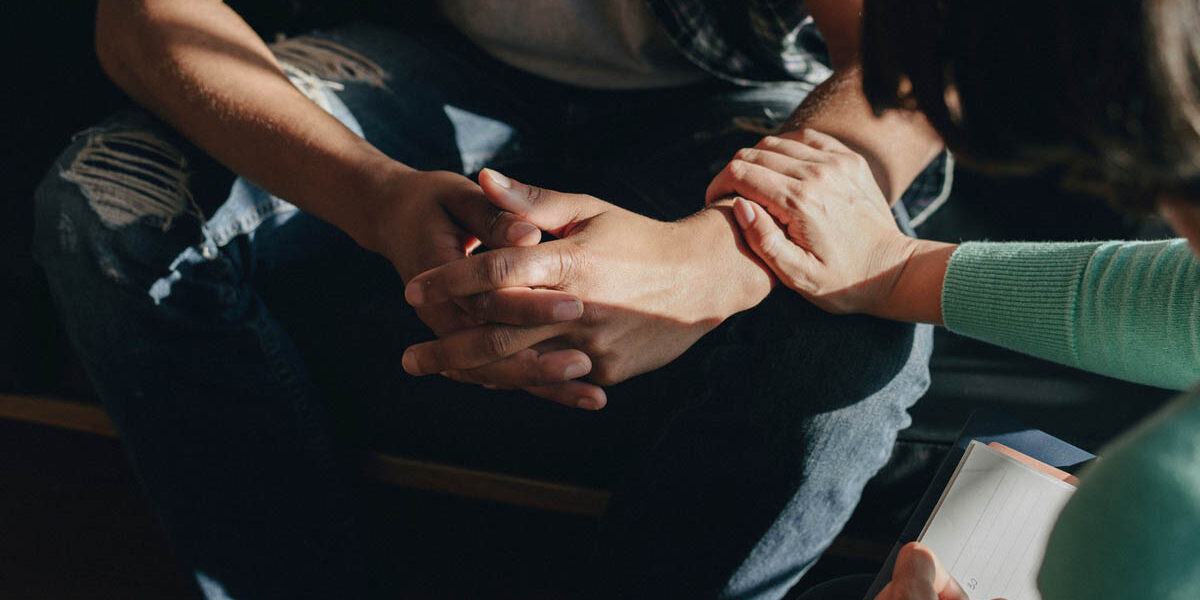 a person consoles another person and puts their hand on their forearm while the person asks how does rehab work