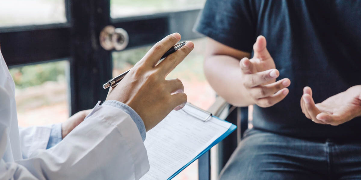 What Does PHP Stand for in Rehab patient moves their hands while asking a specialist about what does php stand for in rehab as the specialist holds a clipboard