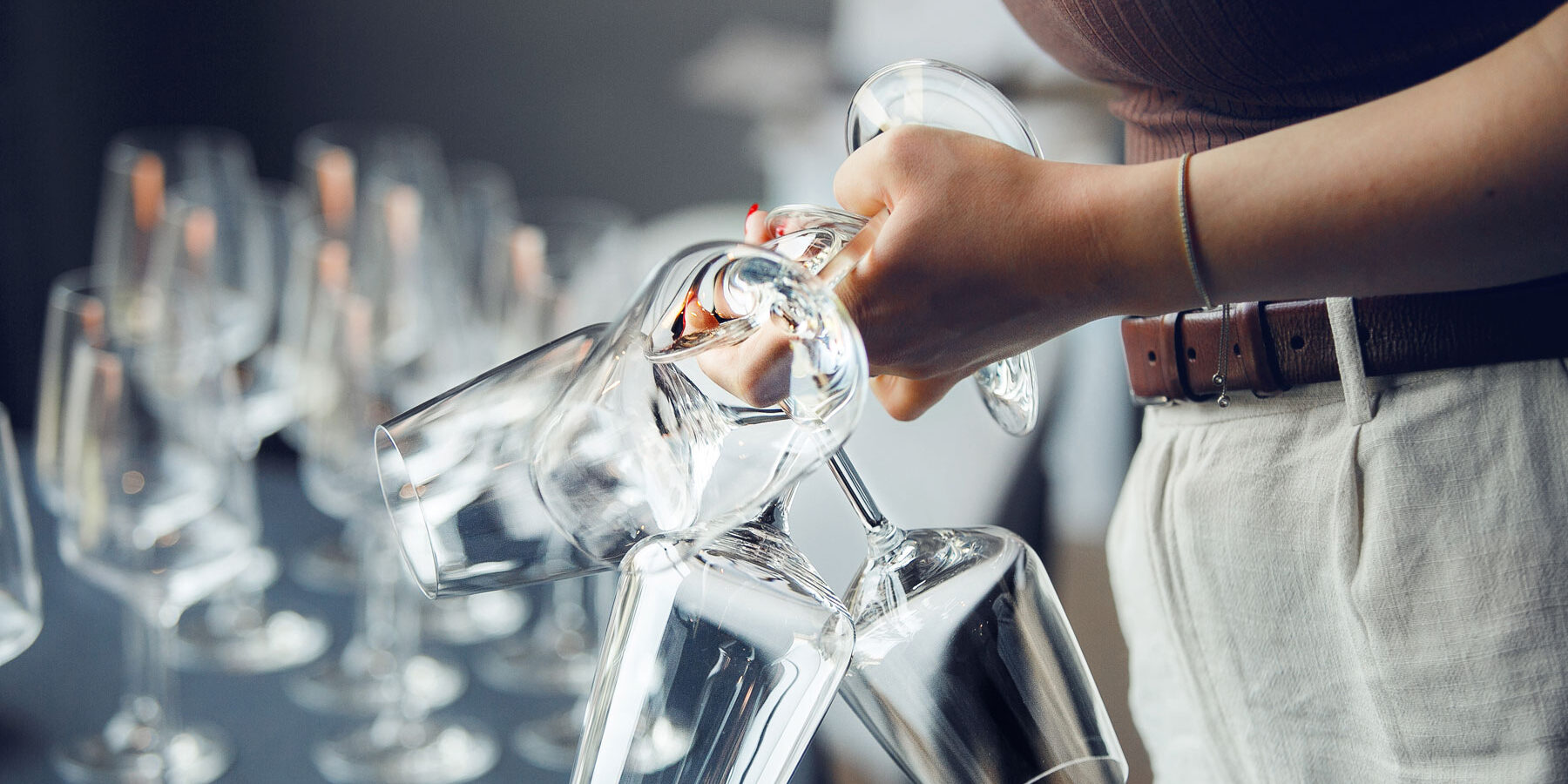 The Dangers Behind Mommy Wine Culture a person holding multiple empty wine glasses while thinking about the dangers of mommy wine culture