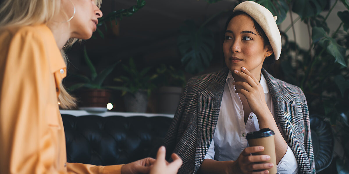 two women sit together and talk discussing the importance of a recovery support network