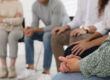 a group of people sit in a circle in group therapy in their medical detox program