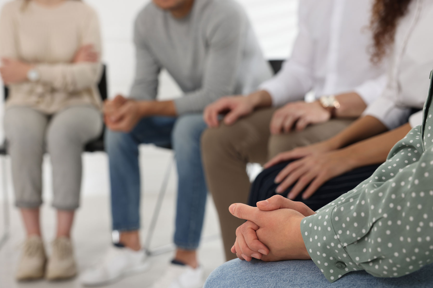 a group of people sit in a circle in group therapy in their medical detox program