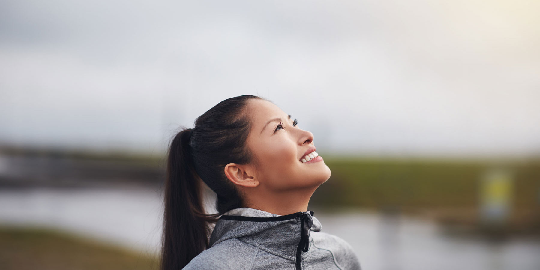 woman outside stares at the sky and wonders about the connection between perfectionism and addiction recovery
