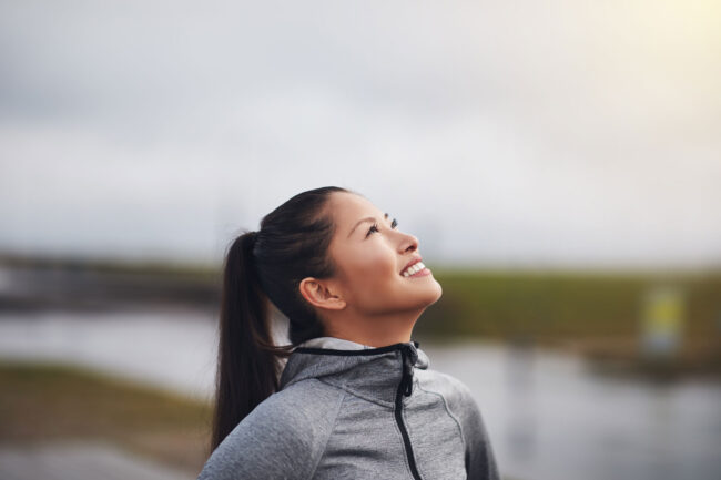 Perfectionism & addiction recovery woman outside stares at the sky and wonders about the connection between perfectionism and addiction recovery