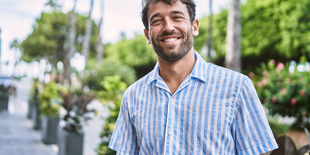 Benefits Of Individual Therapy For Addiction smiling man stands outside experiencing the benefits of individual therapy for addiction