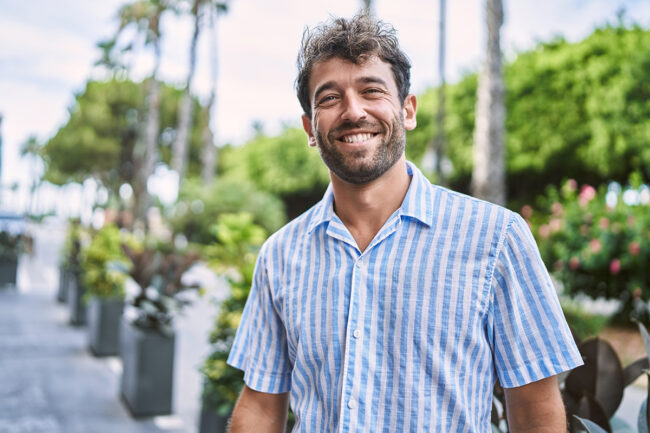smiling man stands outside experiencing the benefits of individual therapy for addiction