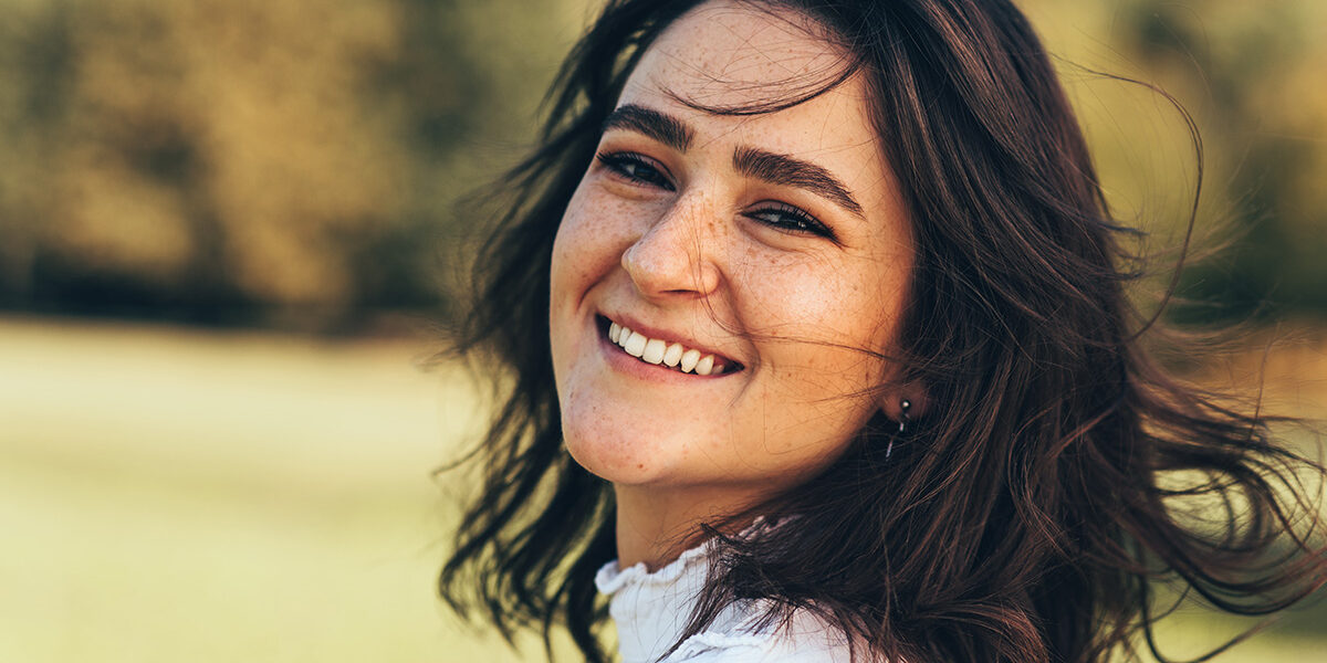 smiling woman is outside thinking about how to detox from alcohol safely