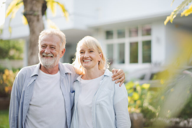 Importance Of Family Support In Recovery an older adult couple smile while standing outside after learning about the importance of family support in recovery