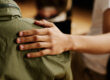 a person consoles another person showing their role in support groups in recovery by placing their hand on a fellow member's shoulder