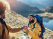 two people hold hands and are hiking on a mountain as one of their effective strategies for preventing relapse