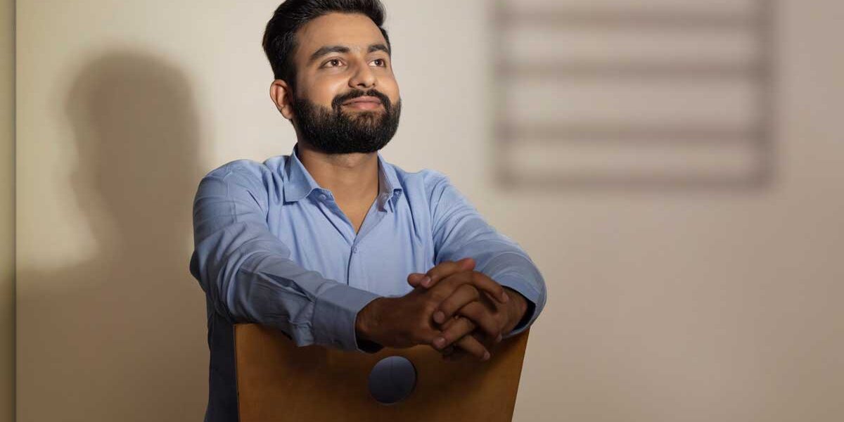 How Long Does Medical Detox Take smiling man stands near a chair and thinks about how long does medical detox take