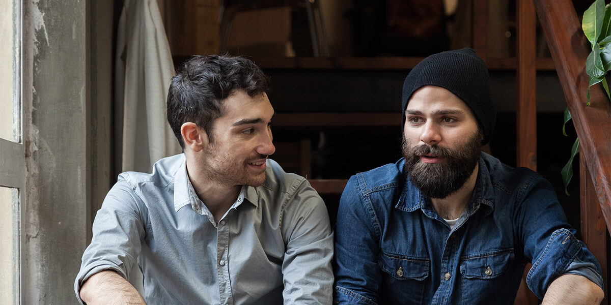 Two men sitting in stairwell having a serious conversation