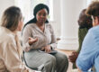 Woman speaking to others in group therapy session