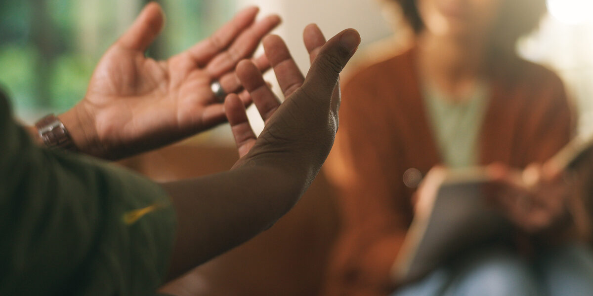 Man explaining to counselor writing in book