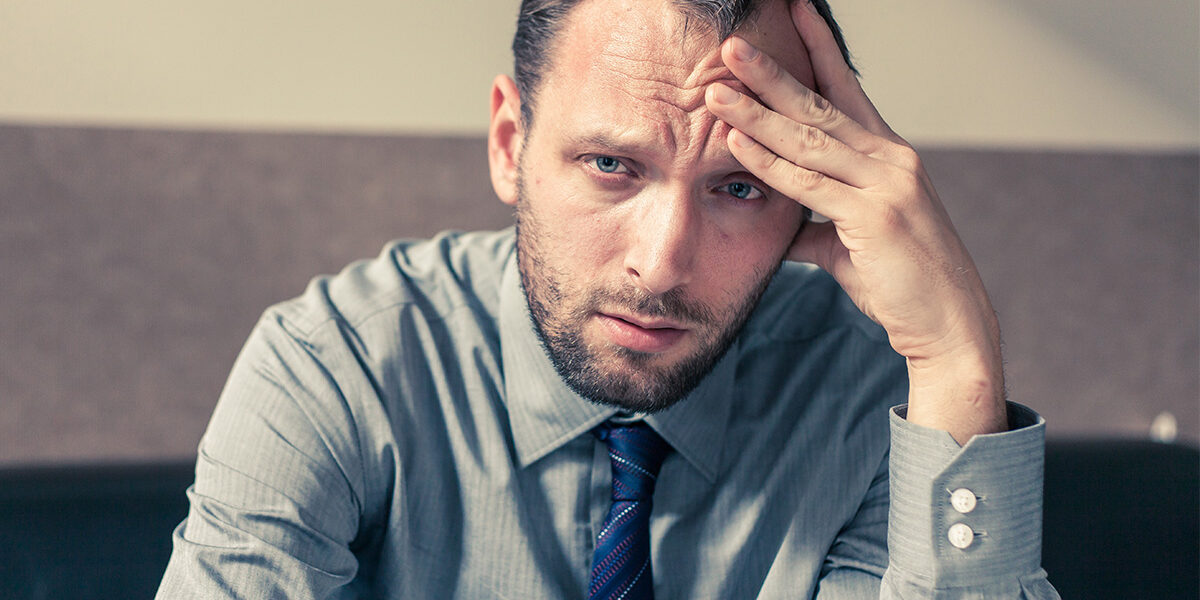 Man in business casual hungover at work